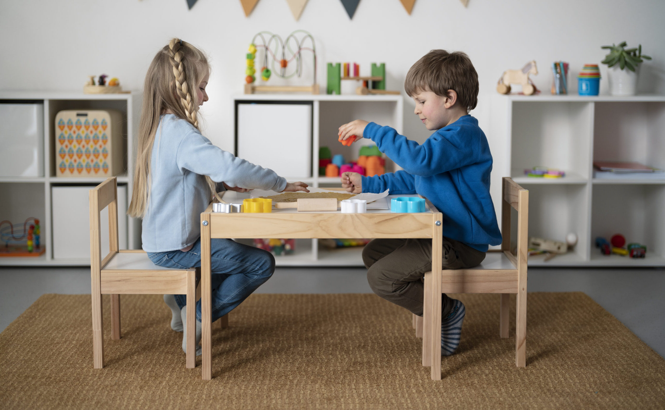 Ganzkörperaufnahme von Kindern, die zusammen am Tisch sitzen